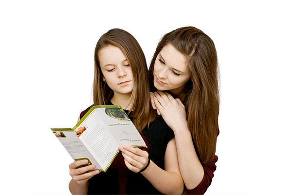 Zwei Jugendliche schauen sich eine Broschüre an